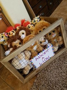 several stuffed animals in a cage with a sign that says adopt a lion on it