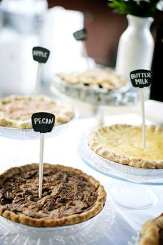 several pies with little signs on them sitting on a table