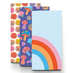 three notebooks with colorful designs on them, one has a rainbow and the other has mushrooms