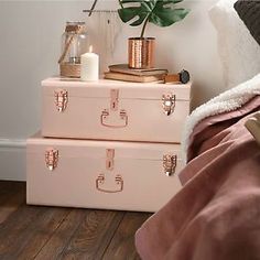 two pink suitcases stacked on top of each other in front of a white wall