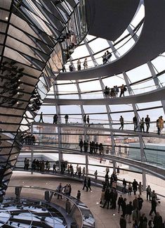 many people are walking around inside the glass dome at the reicher museum in berlin, germany