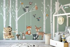 a child's room decorated with woodland animals and trees, including a swing set