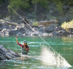 a man is fishing in the water with his rod