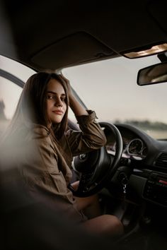 a woman sitting in the driver's seat of a car