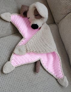 a crocheted stuffed animal laying on top of a couch