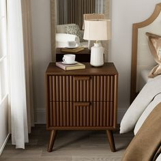 a bedroom with a bed, night stand and lamp on it's side table