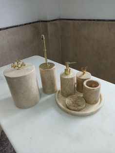 marble bathroom accessories sitting on top of a white counter