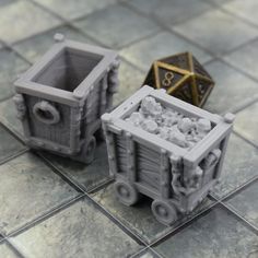 two plastic containers sitting on top of a tile floor next to a metal dice holder