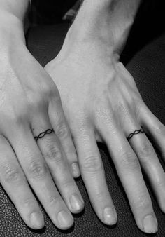 two hands with rings on their fingers and one holding the other's hand out