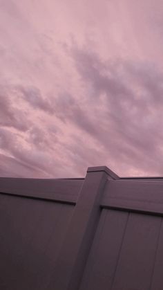 an airplane is flying in the sky over a building