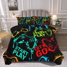 a bed covered in black comforter with colorful video game themed sheets and pillow cases