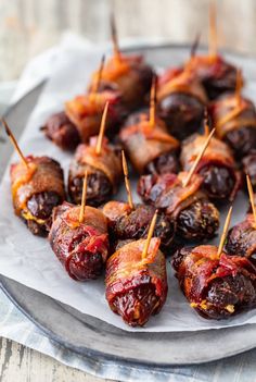 bacon wrapped dates with toothpicks on a plate