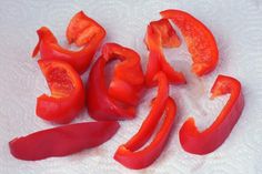 sliced red peppers sitting on top of a white towel