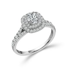 a white gold ring with diamonds on the band and an oval center stone surrounded by small round