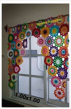 the window is decorated with colorful crochet flowers