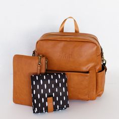 three pieces of luggage sitting next to each other on a white surface with one bag in the foreground