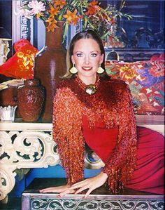 a woman in a red dress sitting on a table