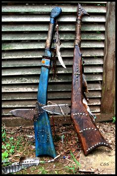 two old broken up wooden instruments sitting on the ground