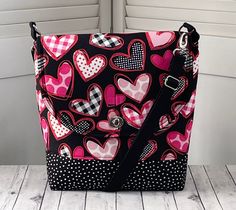 Pink and Black Hearts Messenger Bag Black and White Polka Dot Shoulder Bag Pink Heart Crossbody Bag Ready To Ship Bag measures approx. 11 wide by 11 tall and 3 inches deep front to back. Adjustable strap adjust from 23 inches out to 53 inches long . 4 interior slip pockets 4 x 6 exterior zippered pocket 8 x 7 Twist Lock Closure  All of My Bags are Constructed with the best stabilizers , fabric and solid nickel hardware .  This is a solid bag which will hold its shape beautifully .  It is sure to last for many years . Seams are double and triple stitched .  My bags are all one of a kind, no two will be exactly the same .  Please visit my shop to see more one of a kind bags. See shop policies for more information. Spot clean, hand wash,gentle cycle, dry flat, cool iron if needed. All shippin Buy Bags, Heart Bag, Black Purses, Black Heart, White Polka Dot, Pink Bag, Pink Heart, Happy Shopping, Messenger Bag