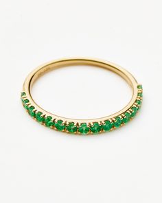 a gold ring with green stones on it