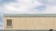 the side of a building with a window on it's roof and sky in the background