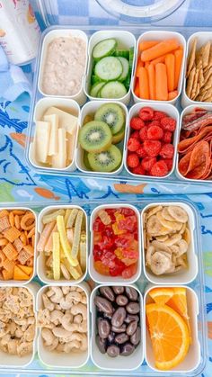 two trays filled with different types of food on top of a blue and white table cloth