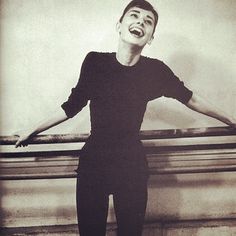 a black and white photo of a woman laughing with her arms stretched out in the air