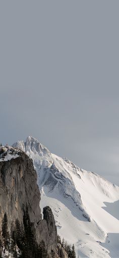 a person standing on top of a snow covered mountain