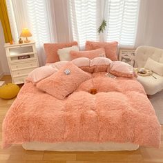 a bed with pink comforters and pillows in a room