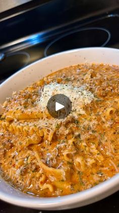 a white bowl filled with pasta on top of a stove