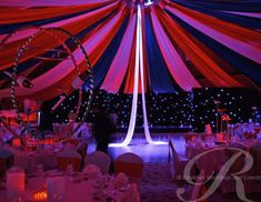 the inside of a tent decorated with red, white and blue draping for an event