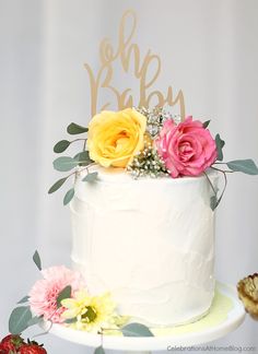 a white cake with yellow and pink flowers on top