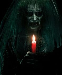 a creepy bride holding a lit candle in her hands