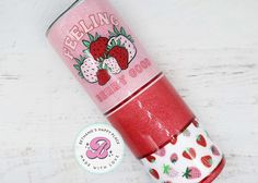 a red travel mug with strawberries printed on it and the lid is open to show its inner sleeve