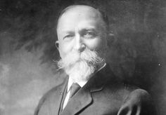 an old black and white photo of a man with a long beard wearing a suit