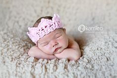 a newborn baby wearing a pink crochet crown