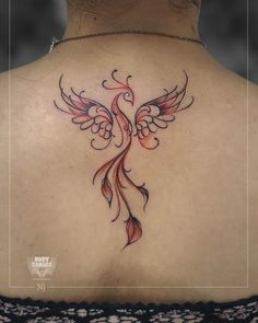 the back of a woman's neck with an intricate tattoo design on her left shoulder