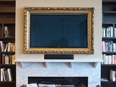 a fireplace with bookshelves and a television mounted on it's wall above the mantle