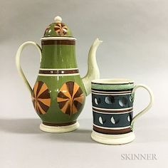 two ceramic teapots with designs on them, one is green and the other is blue