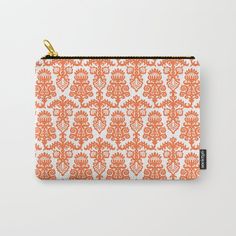 an orange and white pattern with gold zipper pouch