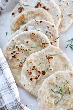 six pita breads on a plate with herbs