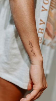 a person with a small tattoo on their left arm and the word love written in cursive font