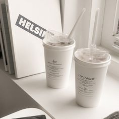 two cups with straws are sitting on a counter