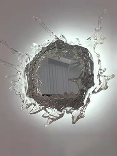 a circular mirror with water splashing around it