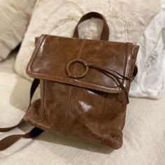 a brown purse sitting on top of a bed