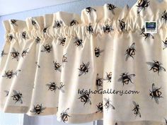 curtains with bees on them hanging in front of a window