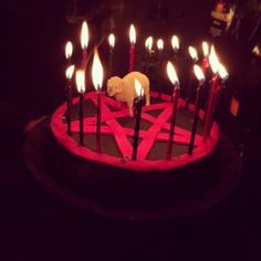 a birthday cake with lit candles in the shape of a sheep on it and an animal figurine