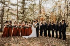 a group of people standing next to each other in front of some trees and leaves