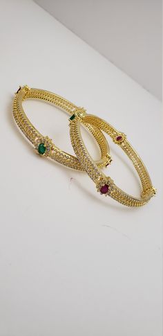 "* Handcrafted Gold Plated Bangle Set * High Quality 22 K Gold Plated 2 pc bangle set; *Bangles Sizes : 2.4 ( 2.30\" diameter of the inner circle) ; 2.6 ( 2.44\" diameter of the inner circle); * Sold as a set of 2 bangles Gorgeous gold-plated bangle/ bracelet best exemplifies the careful craftsmanship done on it -- a specialty at Nemali Jewelry. It has special tone of elegance attached to it. The intricate handmade design of the bangle / bracelet set gives it a fresh and original look. Look your Jeweled Round Bangle For Wedding, Stone Work Bangle Jewelry For Marriage, Bangle With Stone Work For Marriage, Green Hoop Jewelry For Wedding, Green Hoop Jewelry For Weddings, Hoop Bangle For Wedding, Green Wedding Bangle With Intricate Design, Heavy Green Bangle For Wedding, Emerald Bangles