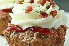 two meatloaf cupcakes with white frosting and toppings on top